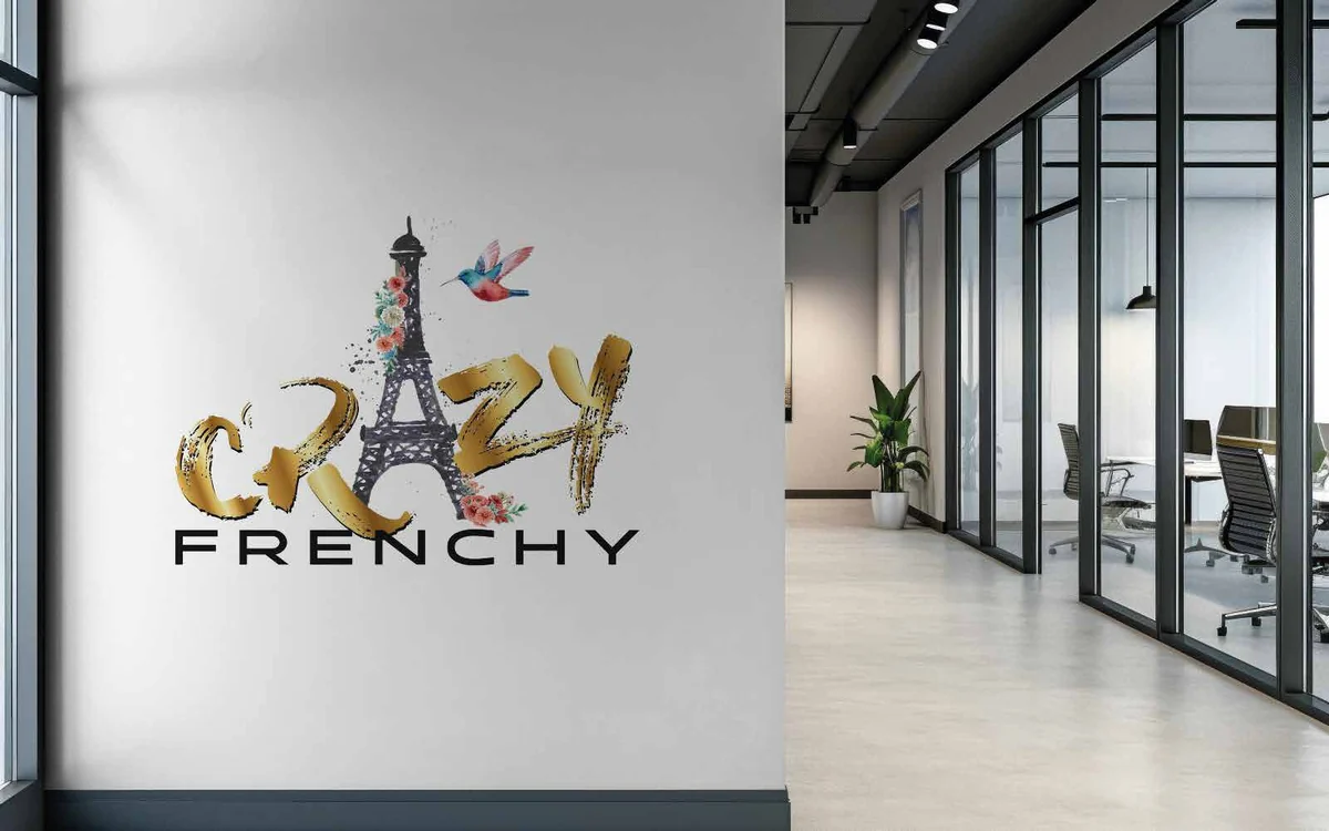 Logo Crazy Frenchy, lettrage doré et tour Eiffel, appliqué en grand sur le mur d'un hall d'entreprise